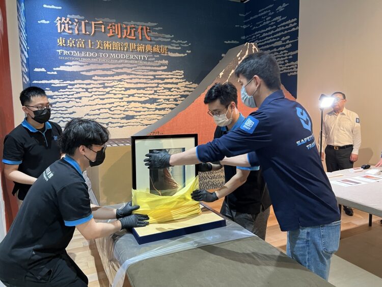 ▲創價美術館布展團隊開箱，取出作品〈富嶽三十六景 山下白雨〉。（圖／創價美術館提供）